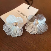 A Pair Of Golden Earrings With Large Flower Design, Simple And Elegant, Unique And Versatile, Giving A Sense Of High-end Fashion And Style.